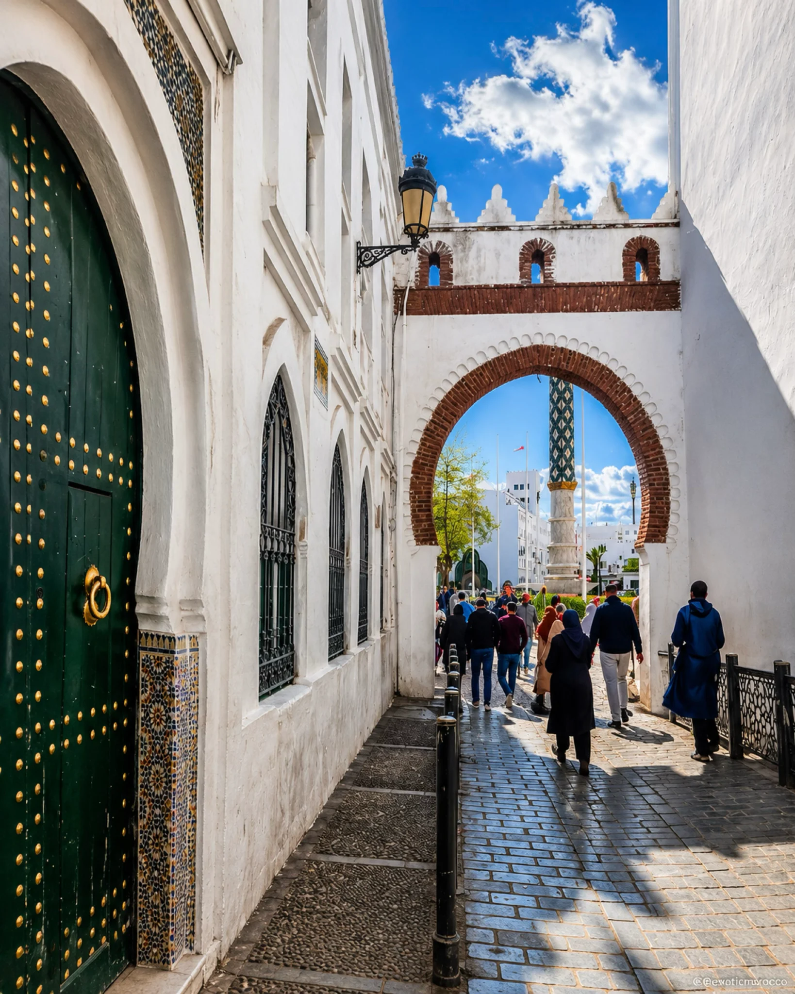Green studded door, white lane and brick arch in Tétouan